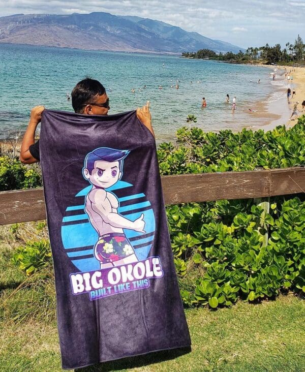 A person holding up a towel with the words " big ohole " on it.