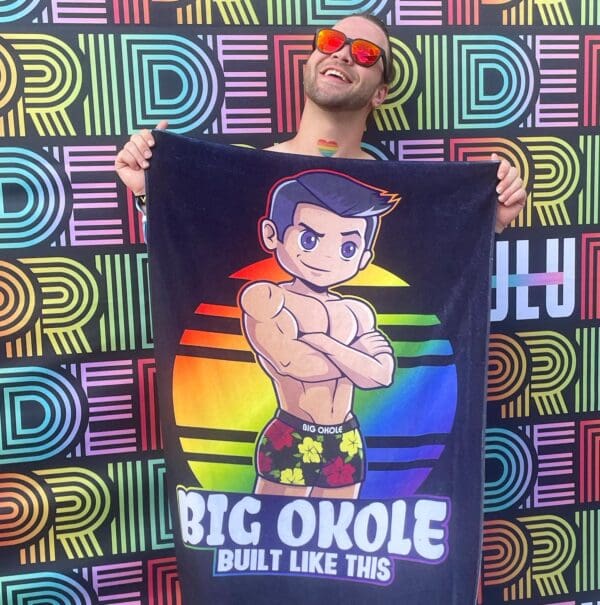 A man holding up a towel with the words " big okole built like this ".